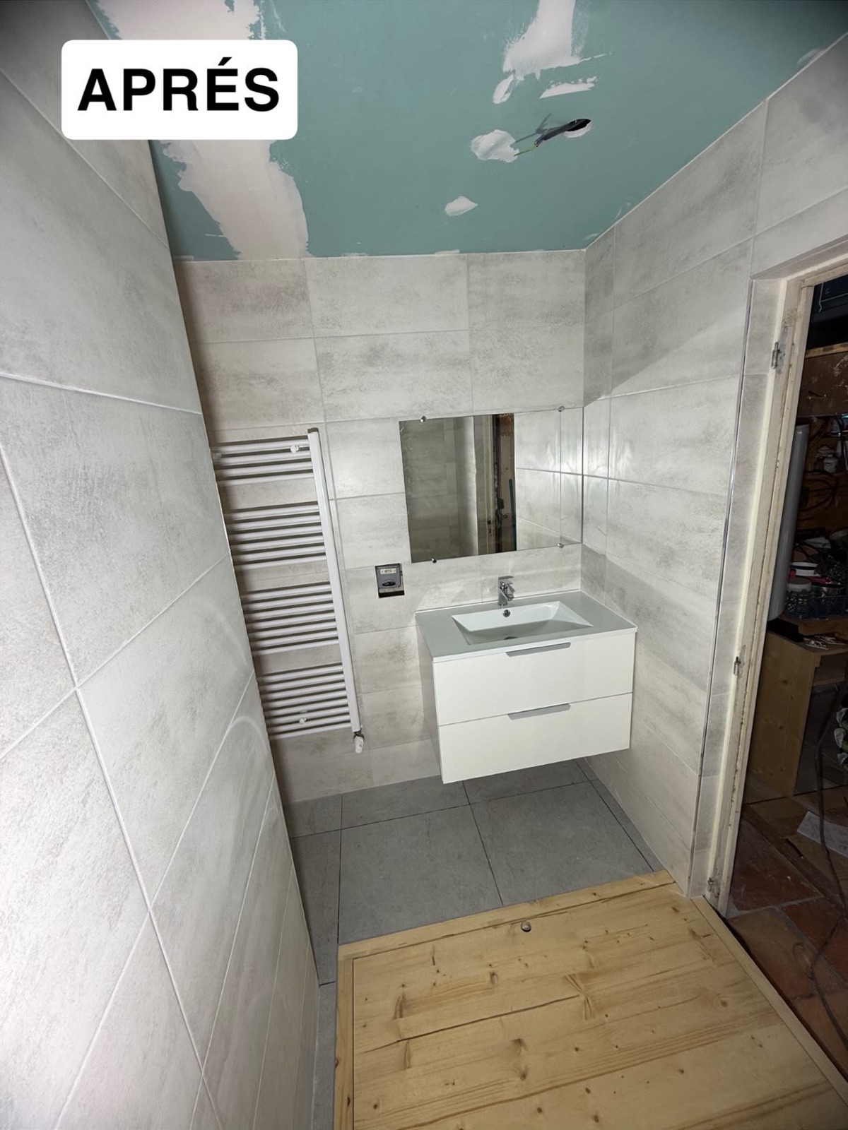 Salle d'eau neuve : meuble vasque suspendu, miroir et sèche-serviettes blanc