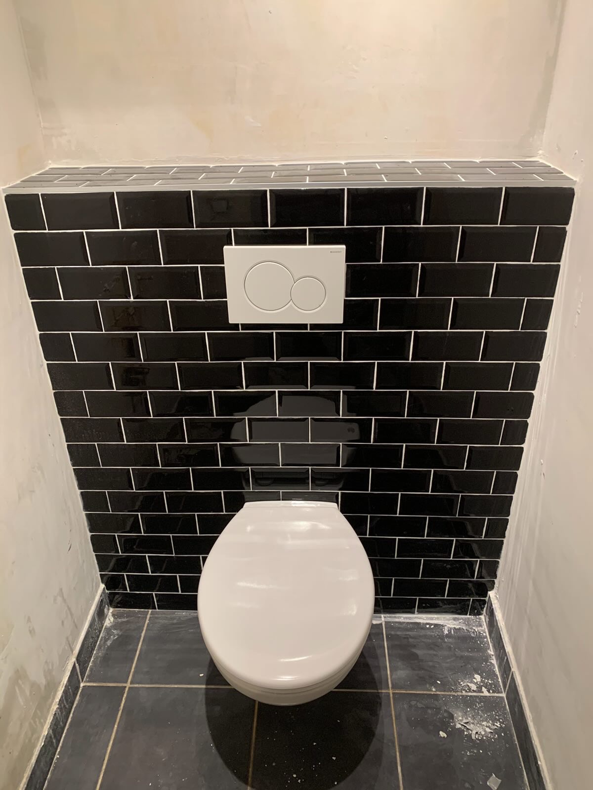 WC suspendu avec carrelage métro noir posé par AEP